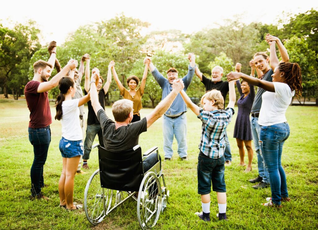 Personnes valides et en situation de handicap réunies dans une ronde – Une scène joyeuse d’inclusion intergénérationnelle et de vivre-ensemble