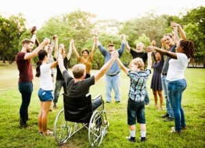 Personnes valides et en situation de handicap réunies dans une ronde – Une scène joyeuse d’inclusion intergénérationnelle et de vivre-ensemble
