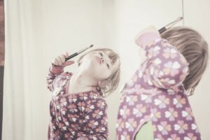 Petite fille se regardant dans le miroir – illustration de l’habitat inclusif et du handicap psychique – Moringa Immobilier